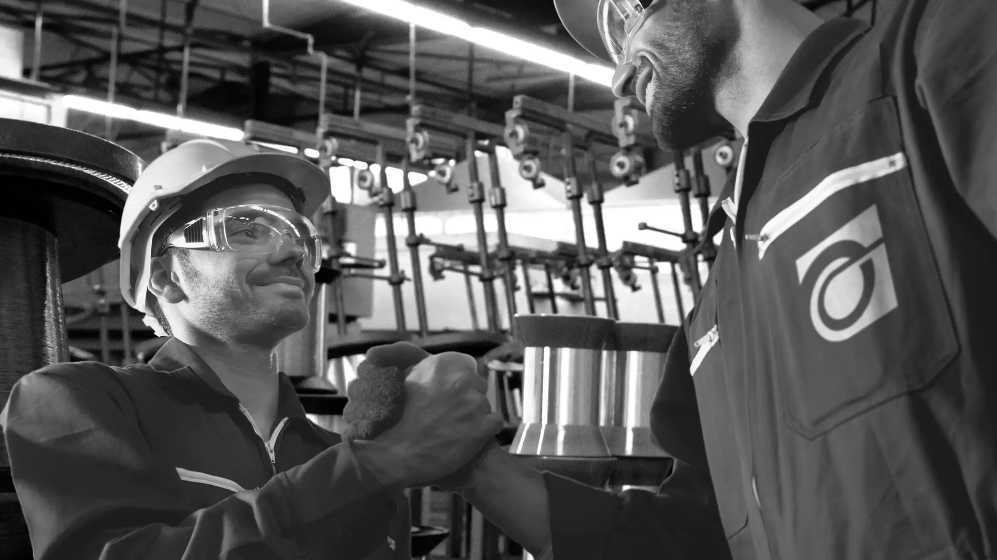 Two BenderWire Group employees shaking hands in the production hall