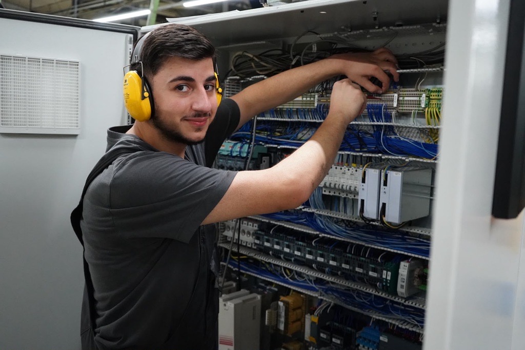 Adem Öztas, Auszubildender Elektriker, bei Arbeiten am Schaltschrank